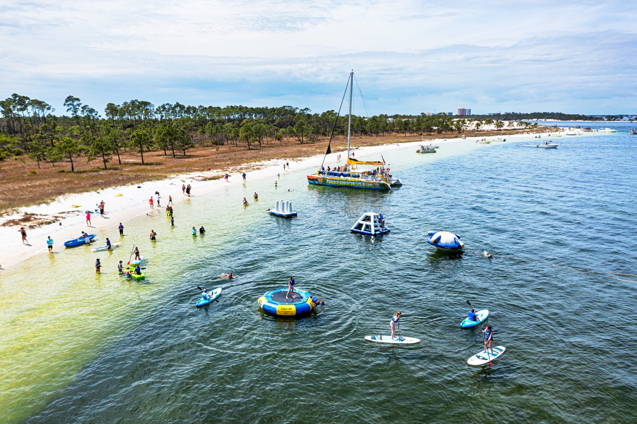 large group playing on water inflatables at shell island